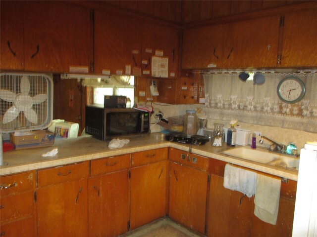 606 E Humble St, Baytown, TX 77520 - kitchen featuring a sink, brown cabinetry, black microwave, and light countertops