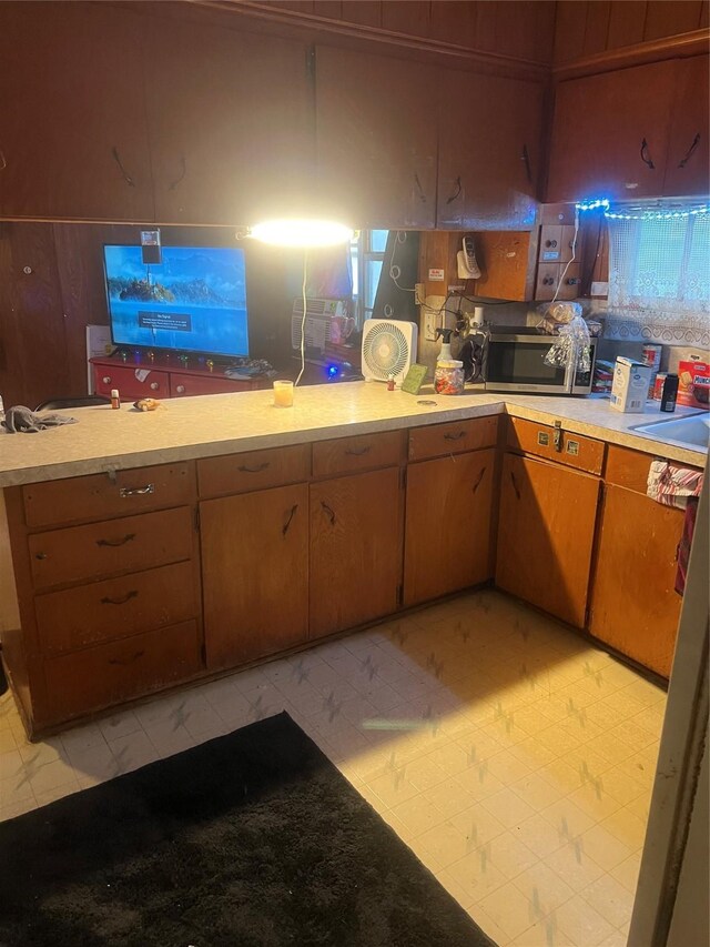 606 E Humble St, Baytown, TX 77520 - kitchen featuring stainless steel microwave, light floors, light countertops, and a sink