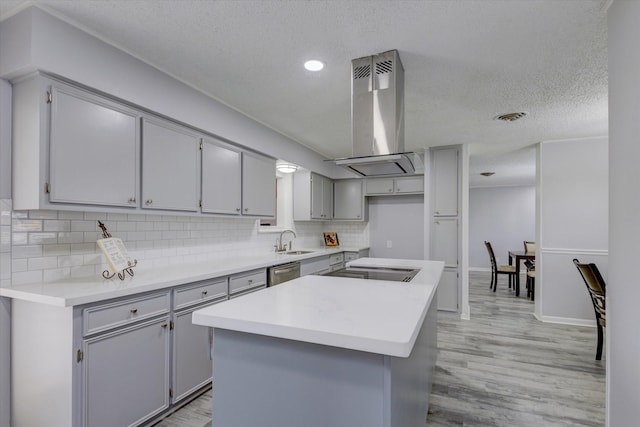 kitchen featuring sink, backsplash, range hood, and a kitchen island