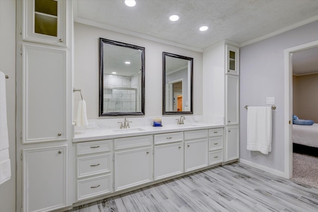 bathroom with wood-type flooring, an enclosed shower, a textured ceiling, crown molding, and vanity