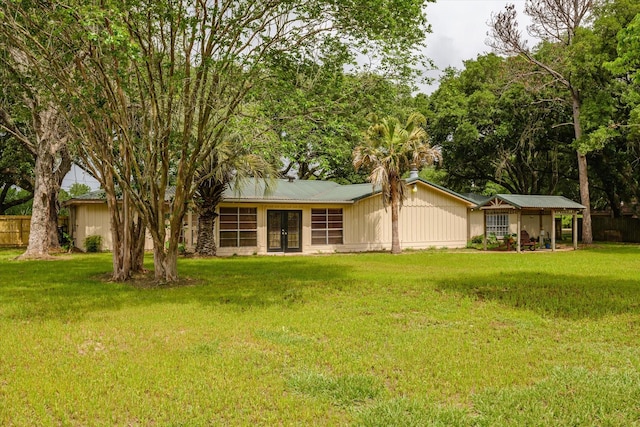 rear view of house featuring a lawn and french doors