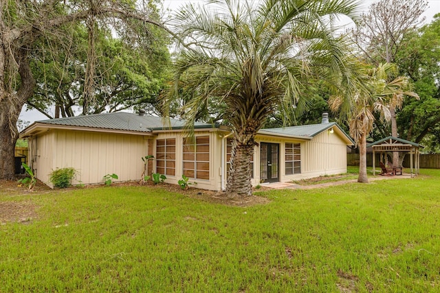 rear view of house with a lawn and a gazebo