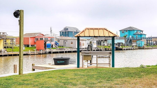 dock area with a lawn and a water view