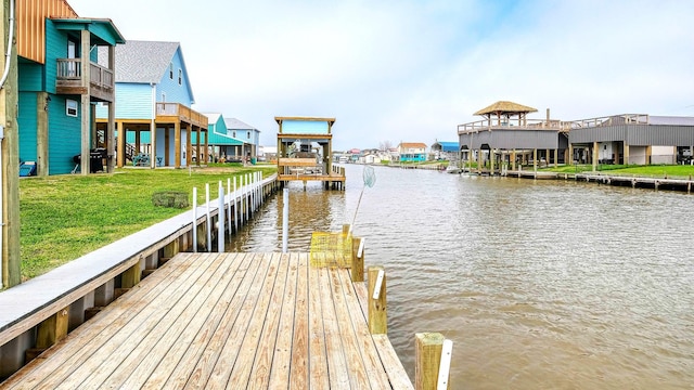 dock area with a water view and a lawn