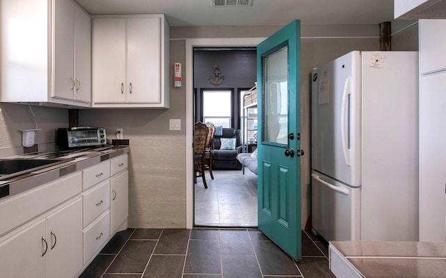 kitchen with white cabinetry and white fridge