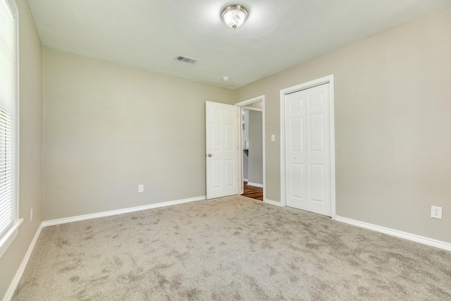 unfurnished bedroom featuring carpet and a closet