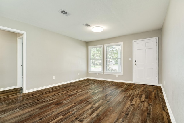 unfurnished room with dark wood-type flooring