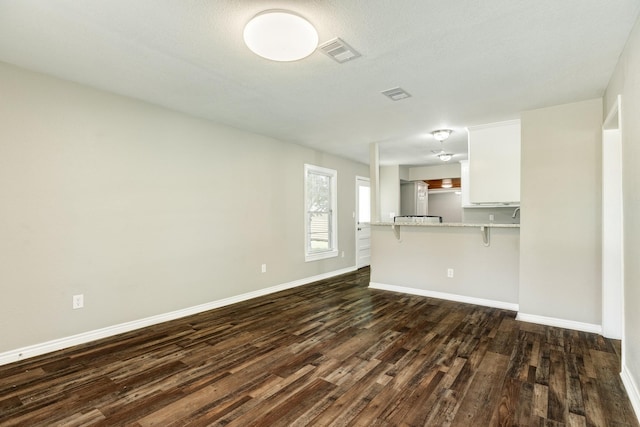 unfurnished living room featuring dark hardwood / wood-style floors and a textured ceiling