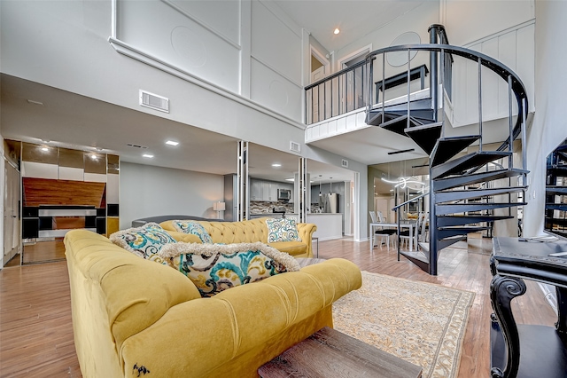 living room with a high ceiling and hardwood / wood-style flooring