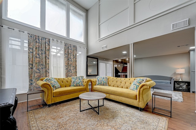 living room featuring a high ceiling and wood-type flooring