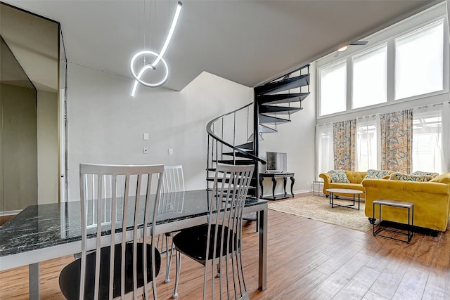 dining area featuring a high ceiling and light hardwood / wood-style floors