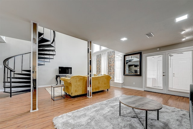 living room with light hardwood / wood-style flooring and french doors