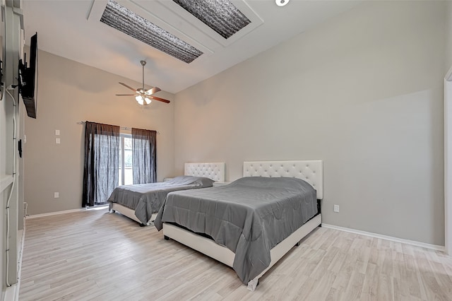 bedroom with high vaulted ceiling, ceiling fan, and light wood-type flooring