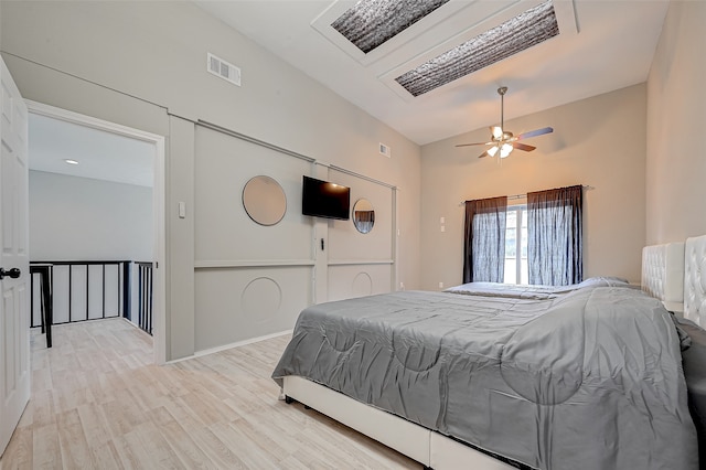 bedroom with ceiling fan, vaulted ceiling, and light wood-type flooring