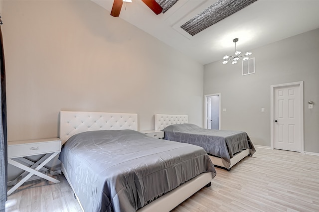 bedroom with high vaulted ceiling, light hardwood / wood-style flooring, and ceiling fan with notable chandelier