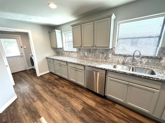 kitchen with sink, light stone counters, stainless steel dishwasher, backsplash, and gray cabinetry