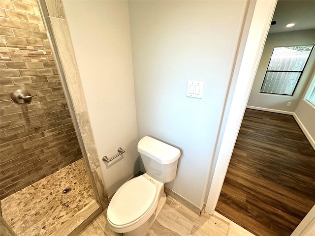 bathroom featuring toilet and a tile shower