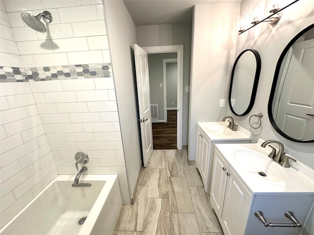 bathroom featuring tiled shower / bath combo, hardwood / wood-style flooring, and vanity