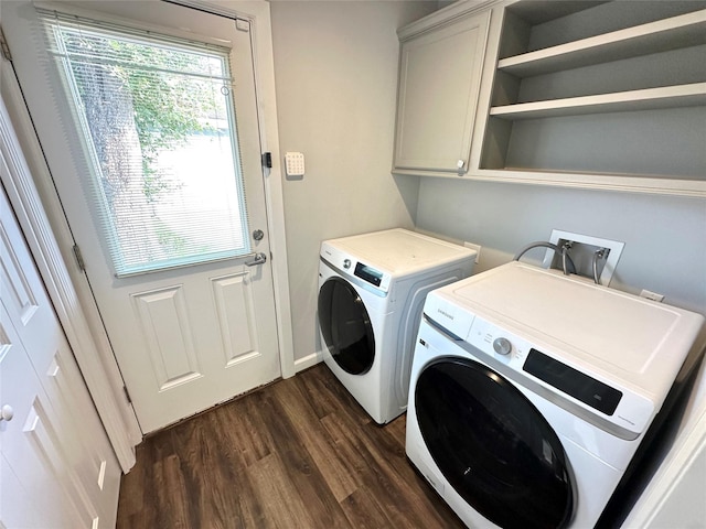 laundry room featuring cabinets, washing machine and clothes dryer, and dark hardwood / wood-style floors