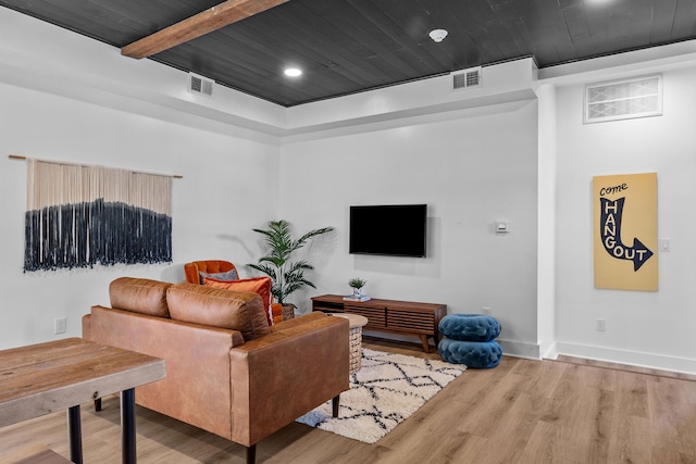 living room featuring beamed ceiling and hardwood / wood-style floors