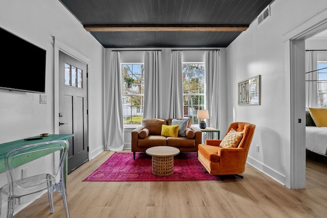 living room featuring beamed ceiling, light hardwood / wood-style flooring, and wooden ceiling