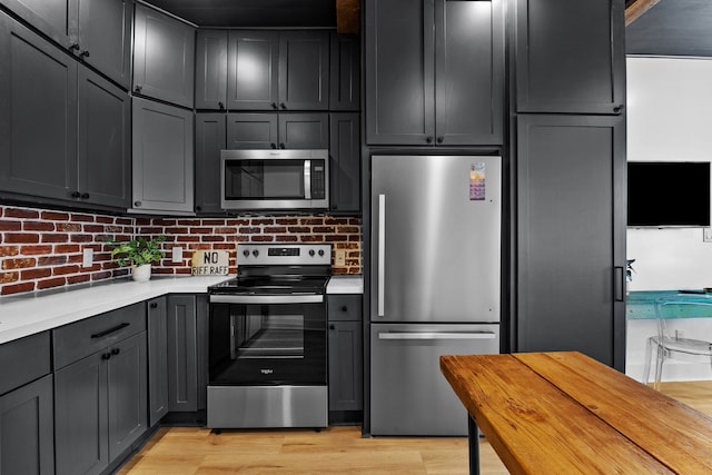 kitchen featuring backsplash, appliances with stainless steel finishes, and light hardwood / wood-style flooring