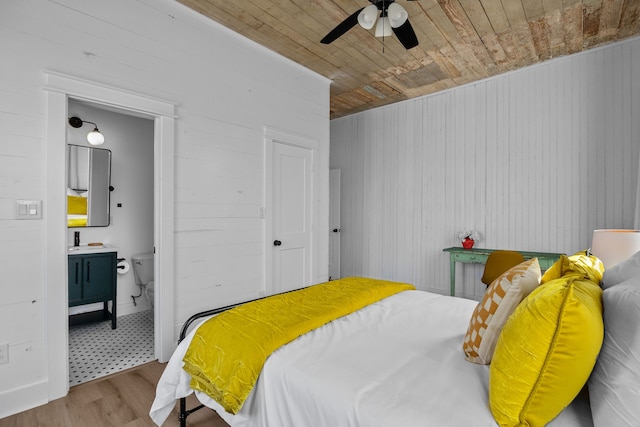 tiled bedroom featuring ceiling fan, ensuite bath, and wood ceiling