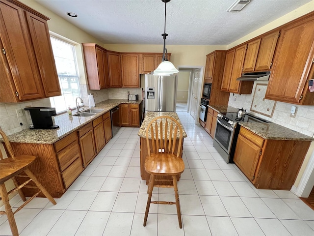 kitchen with sink, hanging light fixtures, dark stone countertops, and black appliances