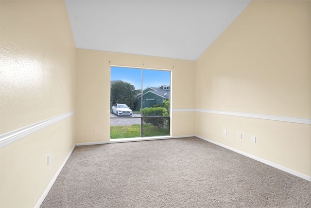 carpeted empty room featuring a wealth of natural light and lofted ceiling