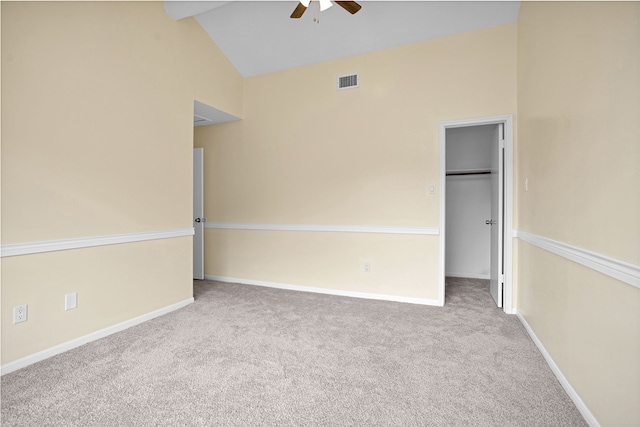 carpeted spare room featuring high vaulted ceiling and ceiling fan