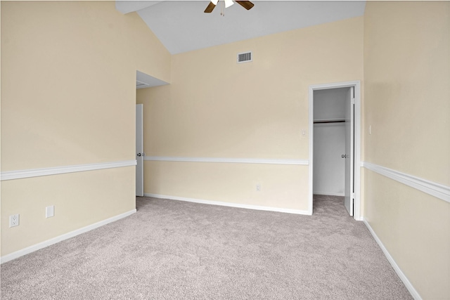 carpeted empty room with ceiling fan and high vaulted ceiling