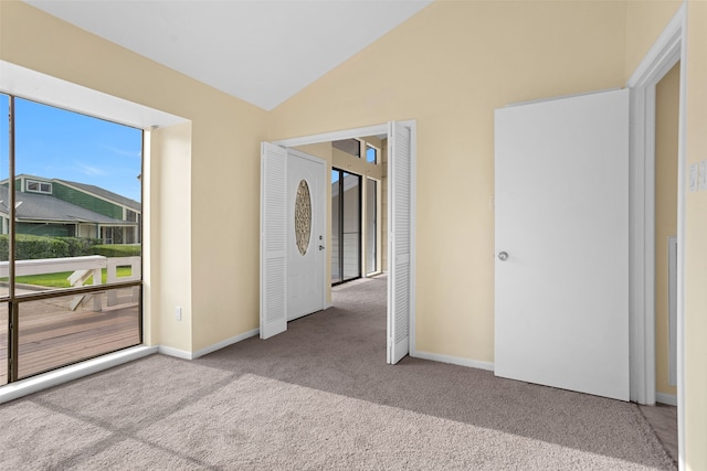 carpeted empty room with lofted ceiling