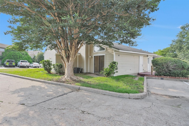 view of front of house featuring central AC and a front lawn