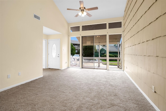 unfurnished living room with ceiling fan, high vaulted ceiling, and carpet flooring