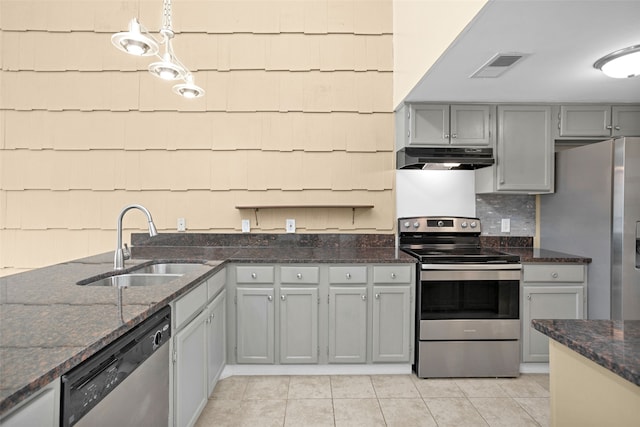 kitchen featuring sink, light tile floors, decorative light fixtures, and appliances with stainless steel finishes