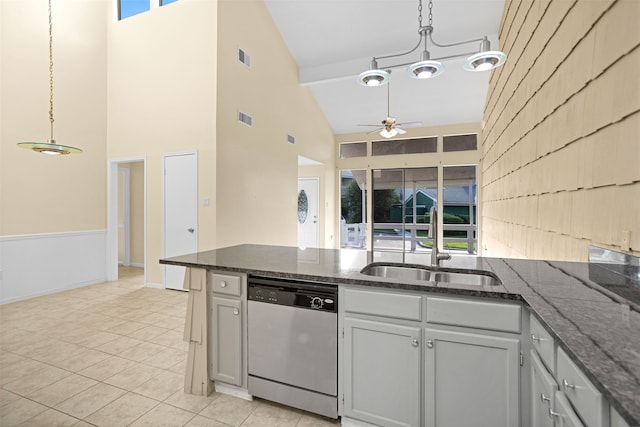 kitchen with high vaulted ceiling, pendant lighting, ceiling fan with notable chandelier, and stainless steel dishwasher