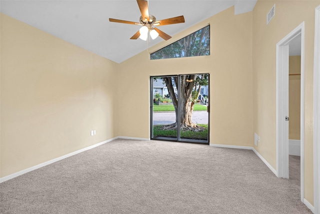 empty room featuring high vaulted ceiling, light colored carpet, and ceiling fan