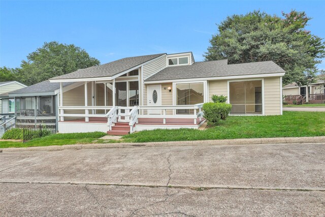 view of front facade featuring a front lawn and a sunroom