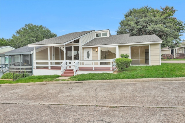 view of front of home with a front yard and a sunroom