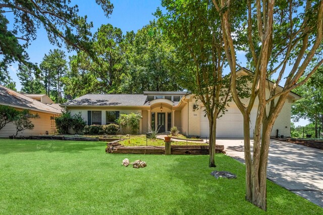 ranch-style home featuring a garage and a front yard