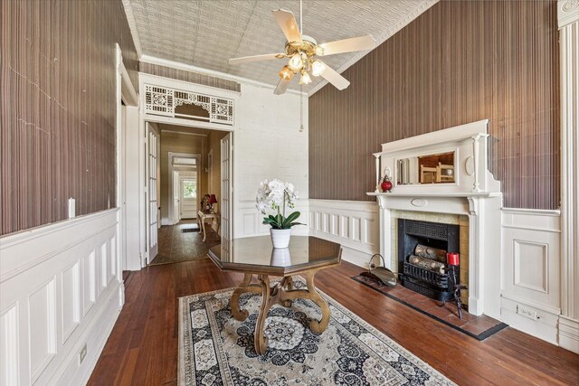 interior space featuring ceiling fan, wood walls, and dark hardwood / wood-style flooring