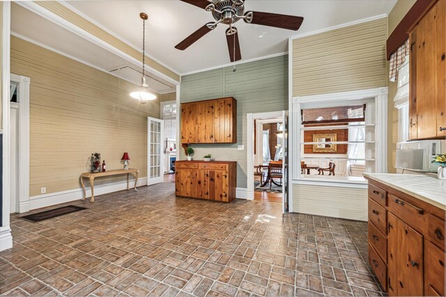 kitchen with ceiling fan, tile countertops, and pendant lighting