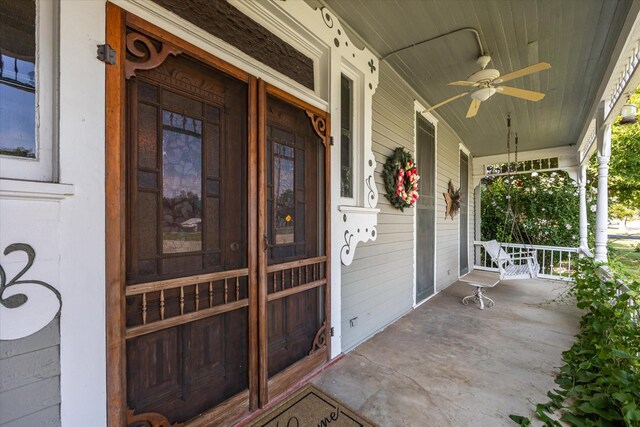 entrance to property featuring ceiling fan and a porch