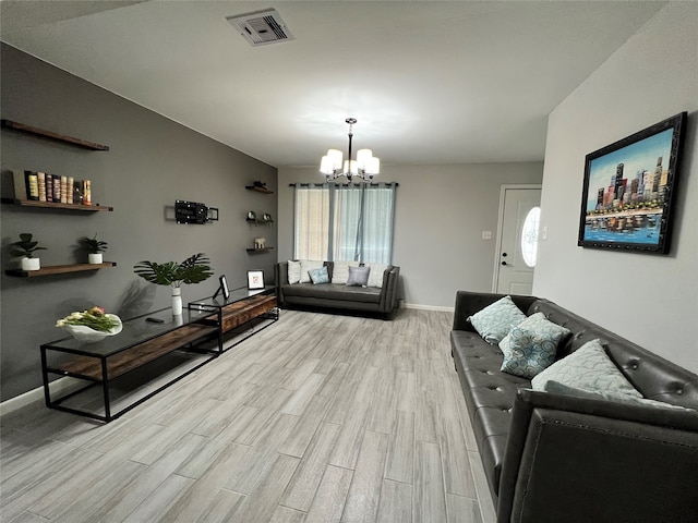 living room featuring a notable chandelier, a wealth of natural light, and light hardwood / wood-style flooring