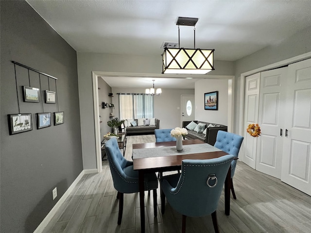 dining space featuring a chandelier and light hardwood / wood-style flooring