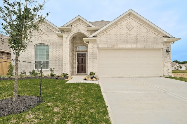 view of front of property with a front yard and a garage