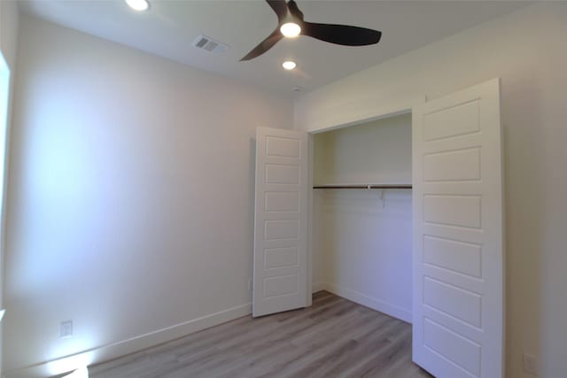 unfurnished bedroom featuring ceiling fan, a closet, and light hardwood / wood-style floors