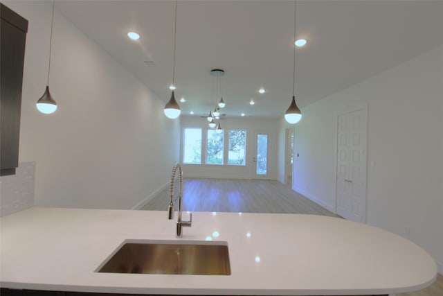 kitchen featuring light hardwood / wood-style floors, sink, pendant lighting, and ceiling fan