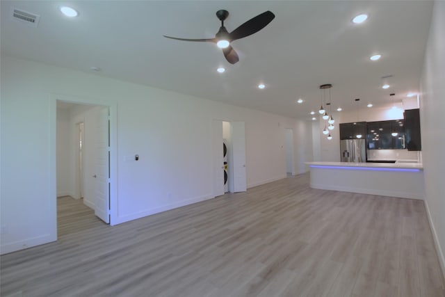 unfurnished living room featuring ceiling fan and light hardwood / wood-style flooring