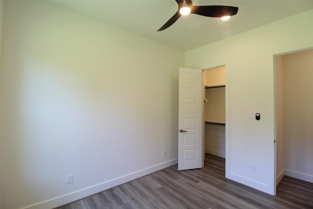 unfurnished bedroom featuring ceiling fan, a closet, and hardwood / wood-style floors